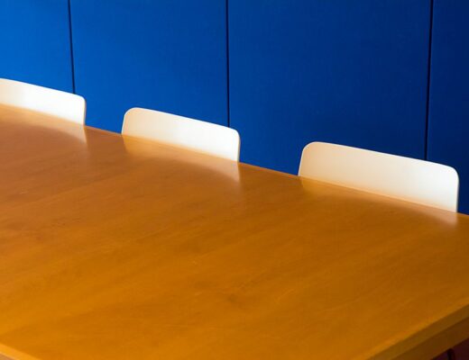 Maatwerk vergadertafel in een moderne vergaderruimte met stoelen.