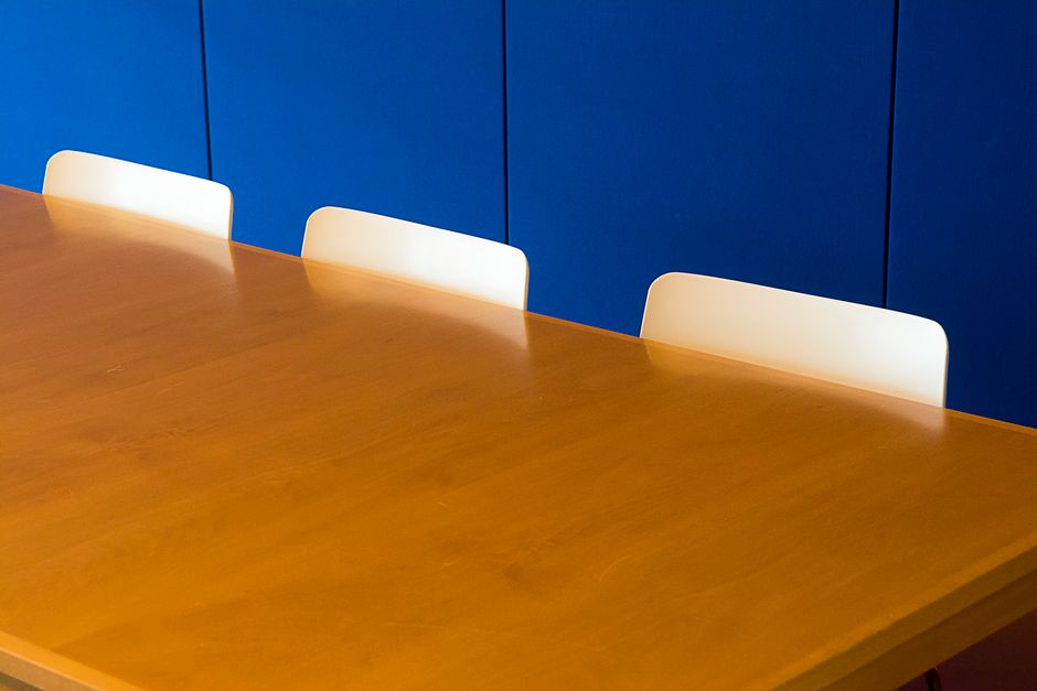 Maatwerk vergadertafel in een moderne vergaderruimte met stoelen.